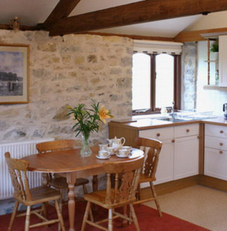 The kitchen in the interior of Wagon House Holiday Cottages in the beautiful Vale of Glamorgan, Wales. table, chairs and well equipped kitchen with large windows and lots of daylight. The converted holiday cottages are situated in a quiet village only 10 minutes walk from the sea